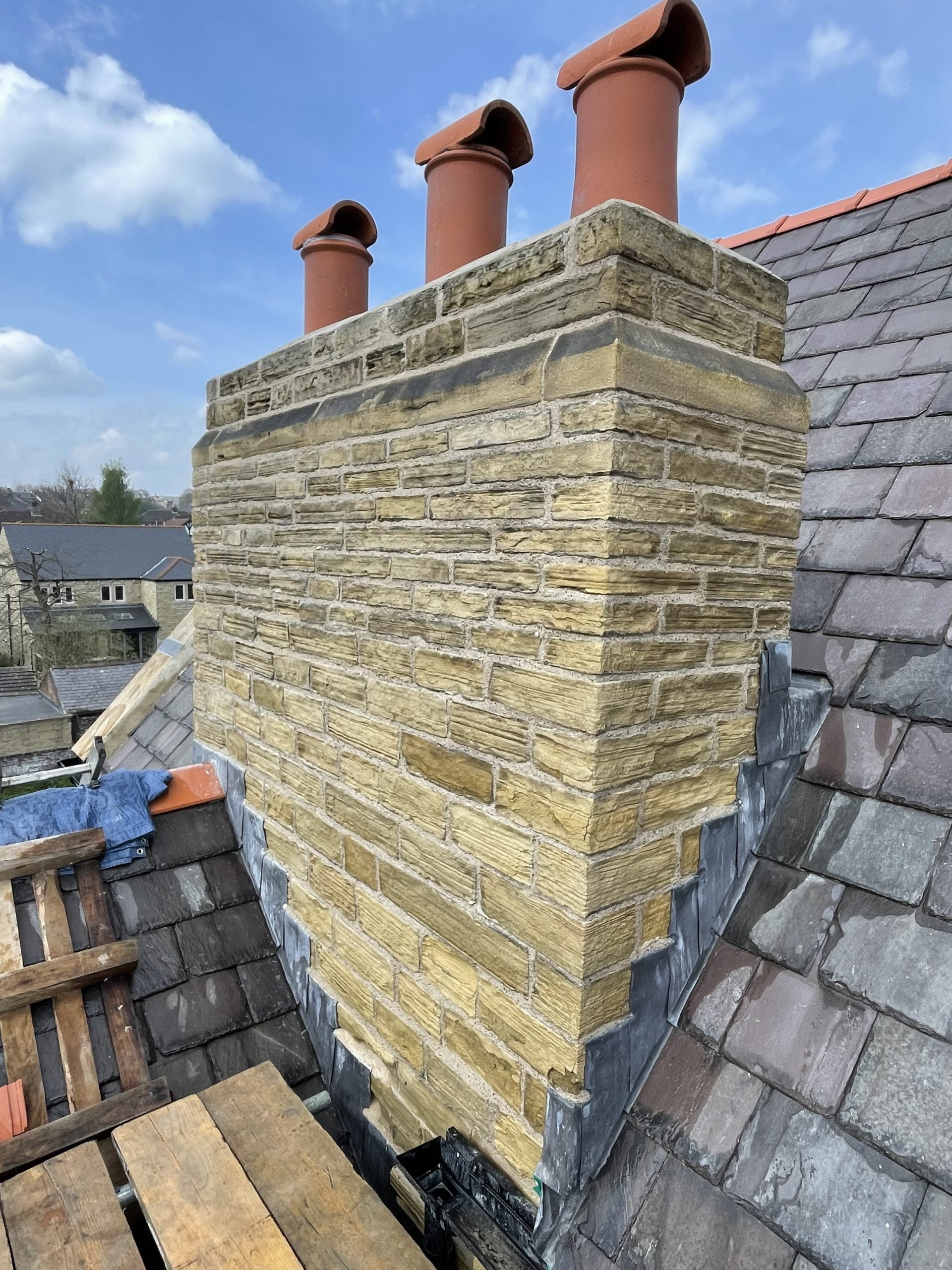Traditional chimney repair. Re-pointing a grade 2 listed stone chimney using hot lime mortar in Huddersfield