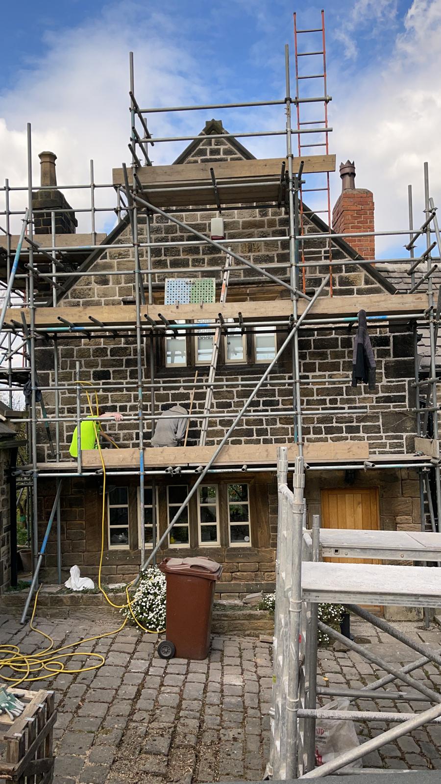 Listed Building conservation. Masonry repairs applying hot lime mortar on a listed building in Chapelthorpe, Wakefield, West Yorkshire
