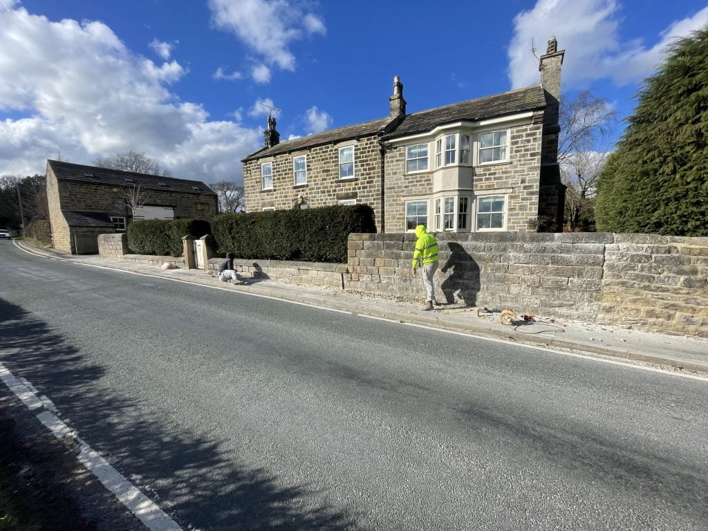 Hot lime pointing a stone boundary wall in pannal. North Yorkshire