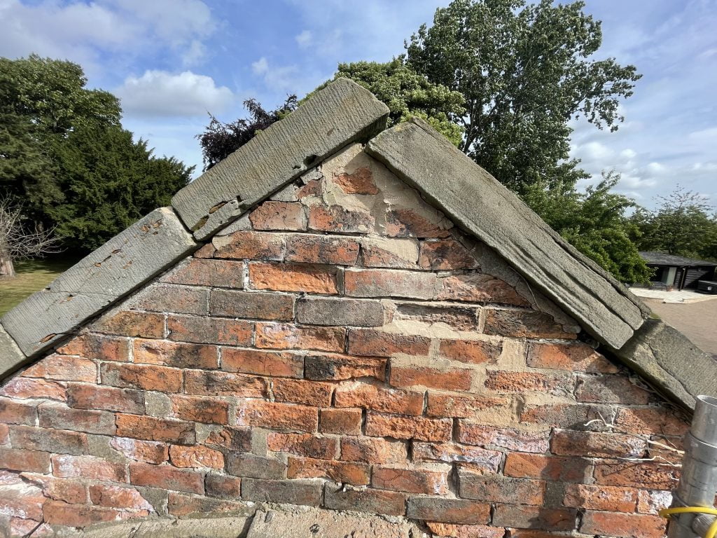Cement pointing covering lime mortar aiding erosion above a brick archway in Ackworth