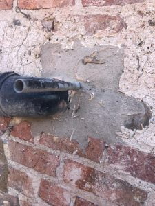 Stone Masonry repairs. Repairing a Cobblestone wall repairs using hot lime mortar in Whixley. North Yorkshire